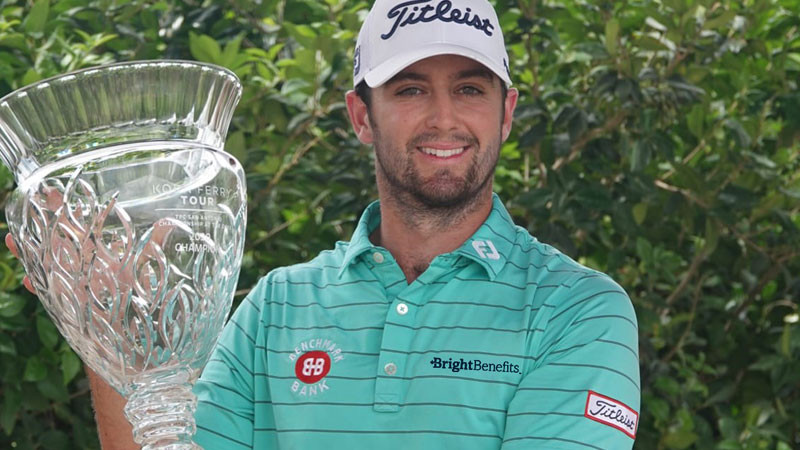 Man holds golf tournament cup after win